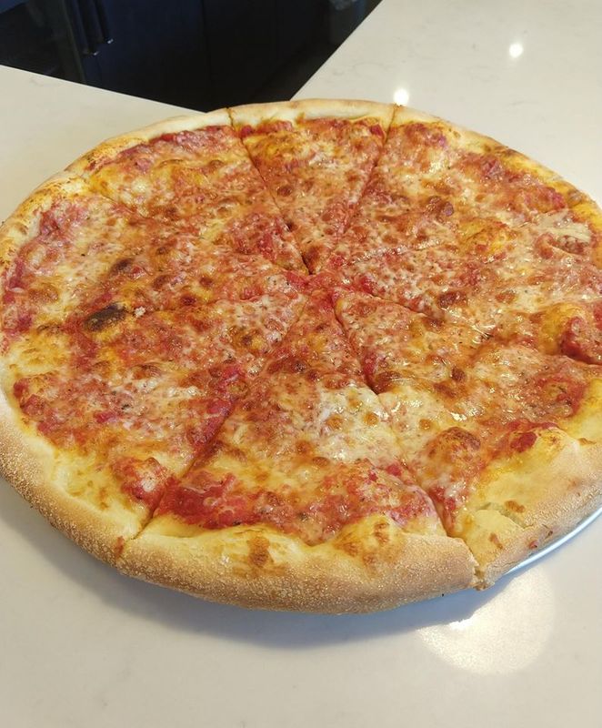 Cheese pizza sliced on counter at Pizza Mark